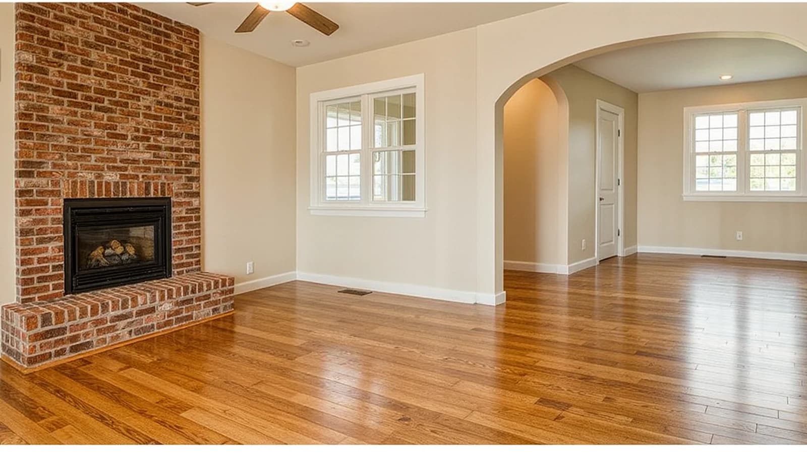 Fictional living room with oak floors and a brick fireplace